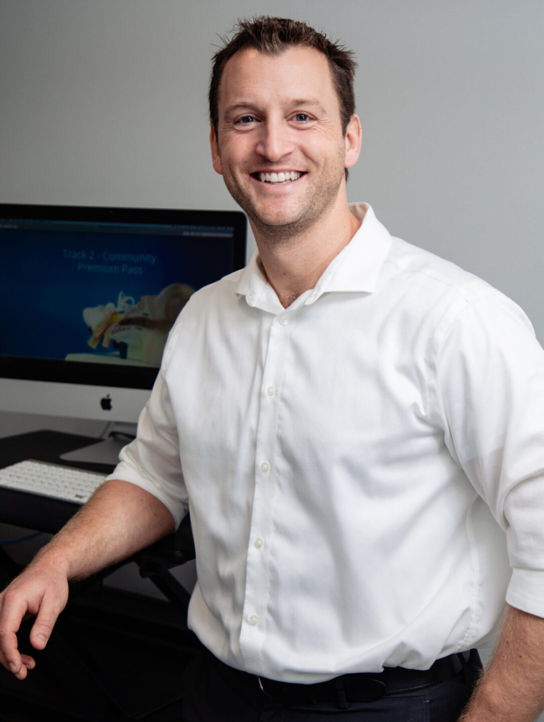 Peter McLeod standing by desk with white shirt on .